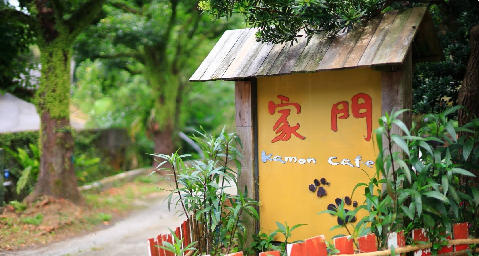 The yellow Kamon Café garden sign